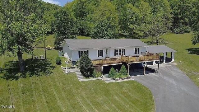 manufactured / mobile home with a front lawn and a carport