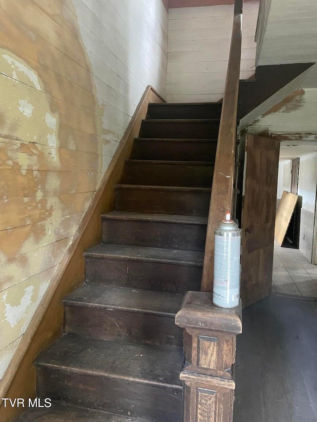 staircase featuring hardwood / wood-style flooring and wood walls