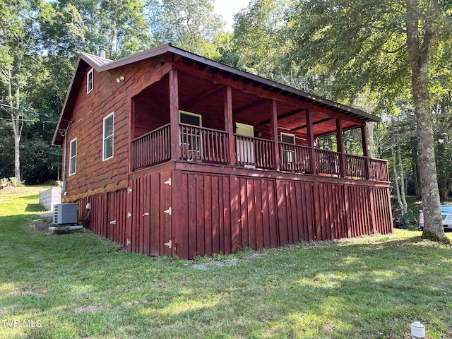 view of side of home with central AC and a lawn