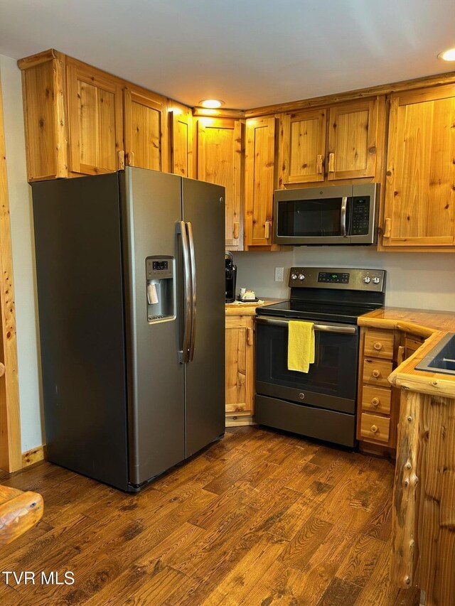 kitchen featuring stainless steel appliances and dark hardwood / wood-style floors