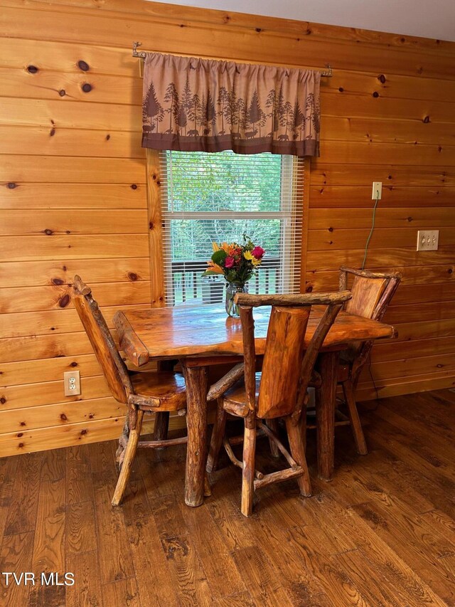 dining space featuring wood walls and hardwood / wood-style flooring