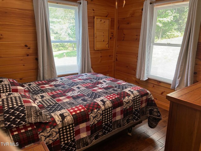 bedroom with wood walls and wood-type flooring