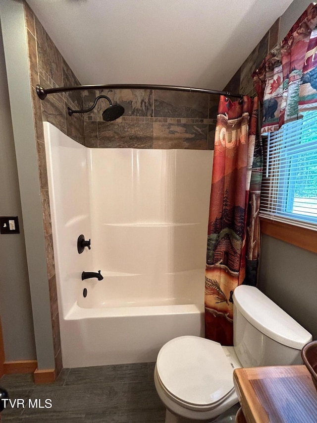 bathroom with shower / bath combination with curtain and toilet