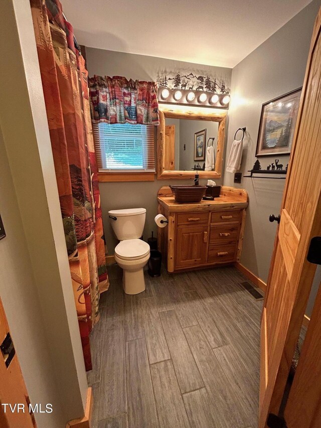 bathroom with hardwood / wood-style flooring, vanity, and toilet