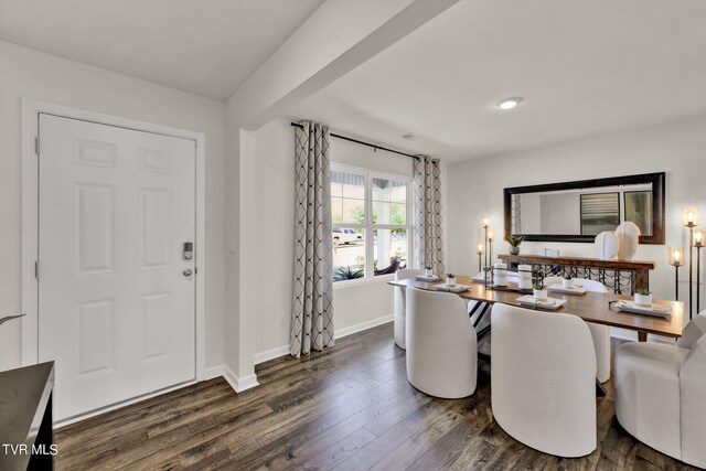 dining room featuring dark hardwood / wood-style floors and beamed ceiling