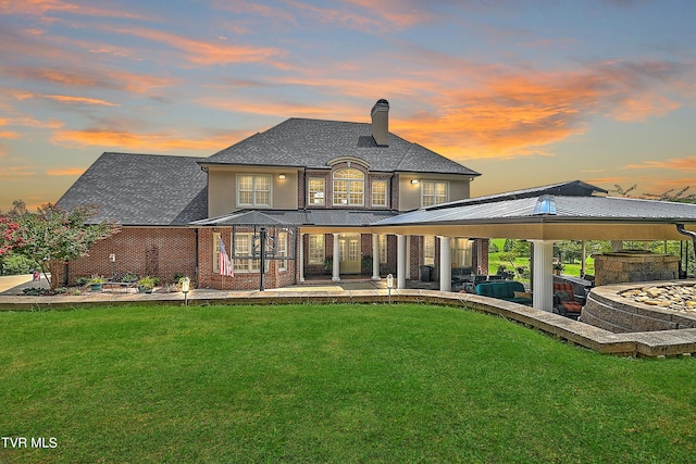 back house at dusk with a gazebo, a yard, and a patio