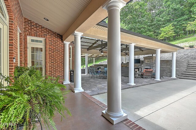 view of patio featuring a fireplace and ceiling fan