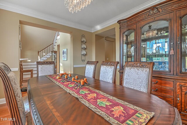 dining space with ornamental molding and an inviting chandelier