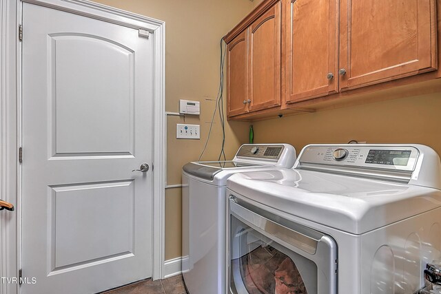 clothes washing area with washing machine and dryer and cabinets