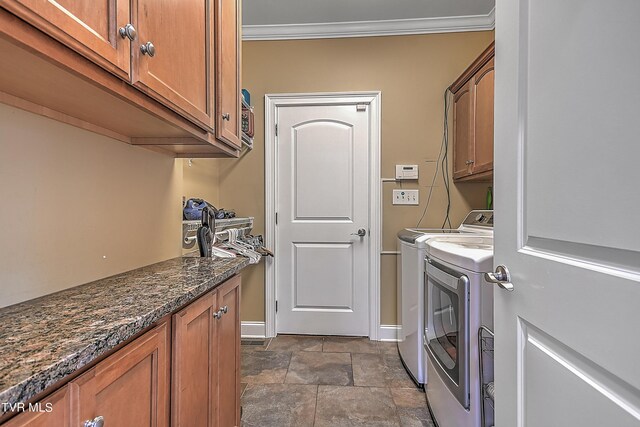 laundry area featuring cabinets, ornamental molding, and washer and clothes dryer