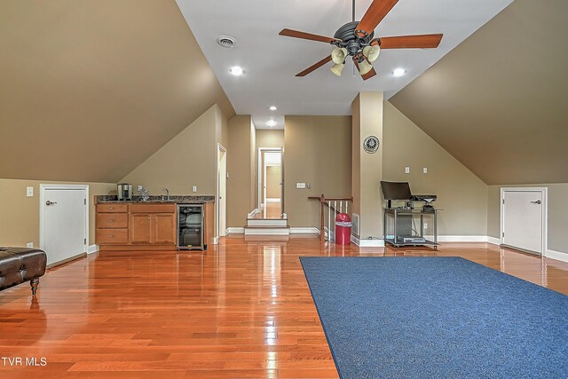 bonus room featuring sink, ceiling fan, wood-type flooring, vaulted ceiling, and beverage cooler