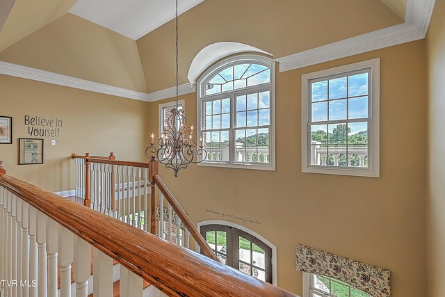 interior space with an inviting chandelier, ornamental molding, and high vaulted ceiling