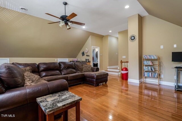 living room with lofted ceiling, hardwood / wood-style flooring, and ceiling fan