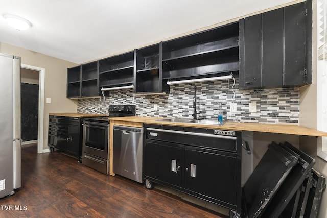 kitchen featuring decorative backsplash, appliances with stainless steel finishes, dark wood-type flooring, sink, and butcher block countertops