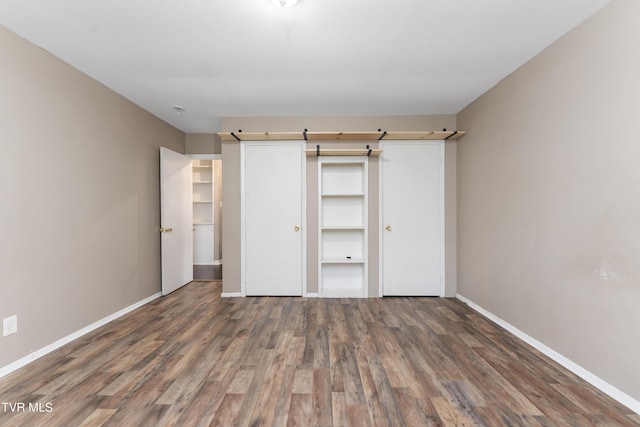 unfurnished bedroom featuring dark wood-type flooring and a closet