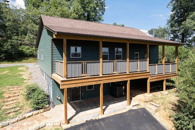 rear view of house with central AC unit and a patio area