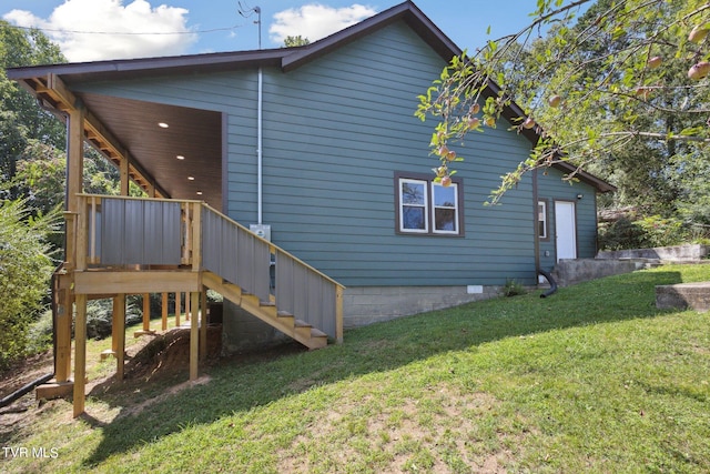 view of property exterior featuring a wooden deck and a lawn