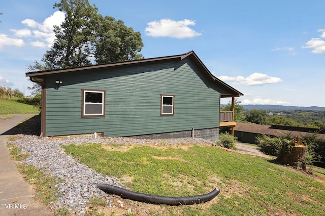 view of home's exterior featuring a deck and a lawn