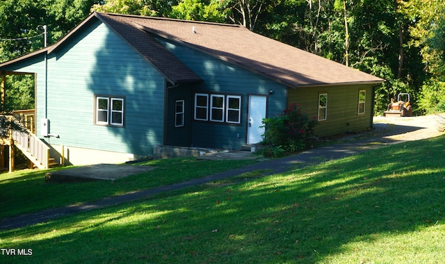 view of side of home with a yard