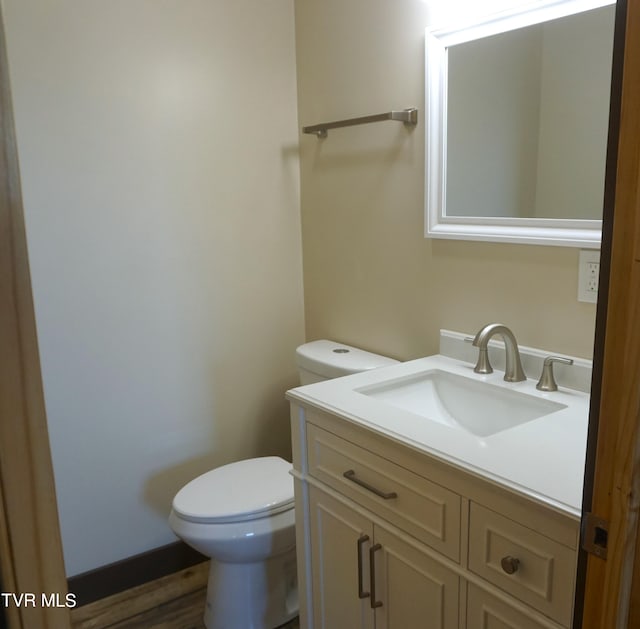 bathroom with vanity, toilet, and hardwood / wood-style floors