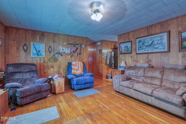 living room with wooden walls and light hardwood / wood-style flooring