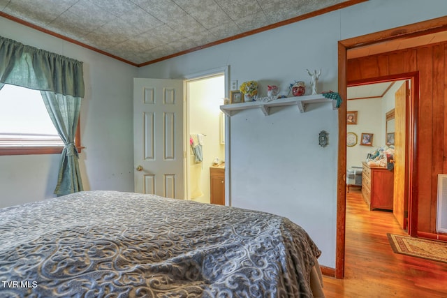 bedroom with light hardwood / wood-style floors and ensuite bath