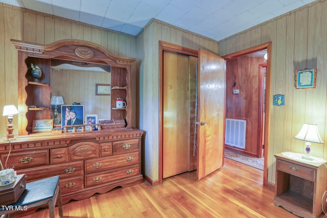 interior space featuring light wood-type flooring and wooden walls