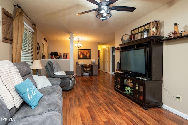 living room with a textured ceiling, ceiling fan with notable chandelier, and dark hardwood / wood-style floors