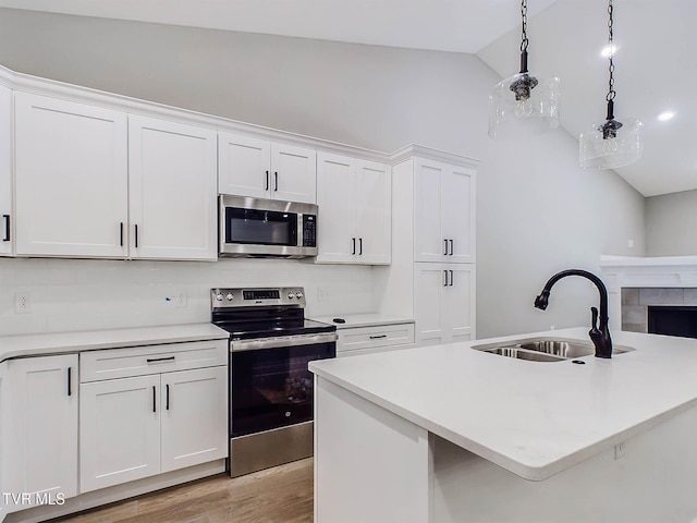 kitchen featuring white cabinetry, sink, stainless steel appliances, and lofted ceiling