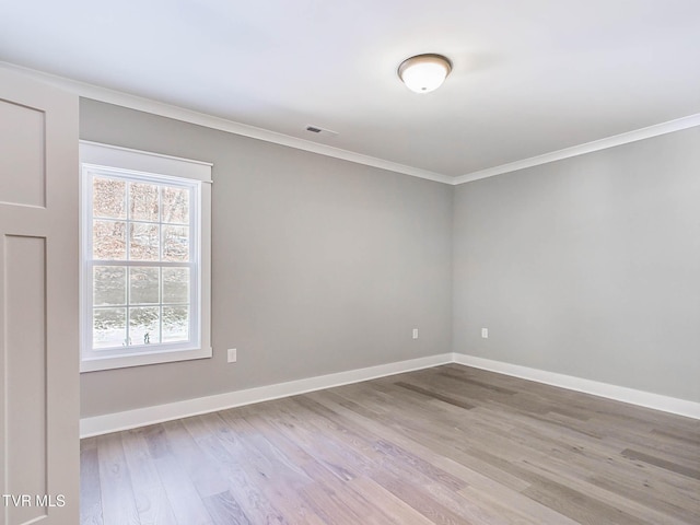 unfurnished room with ornamental molding and light wood-type flooring