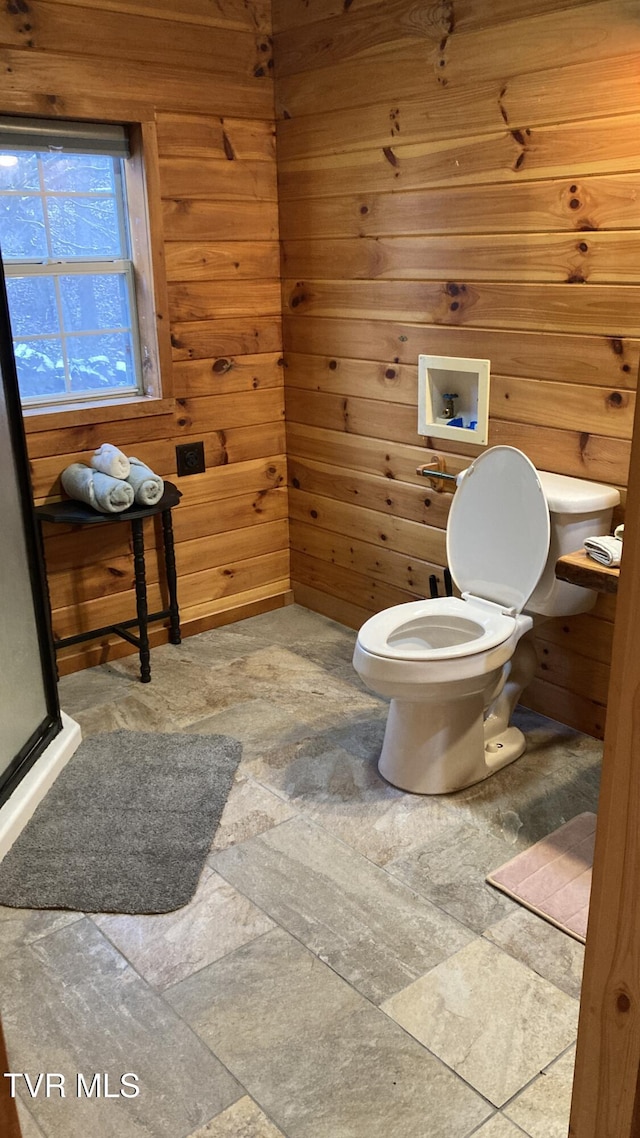 bathroom with toilet and wooden walls