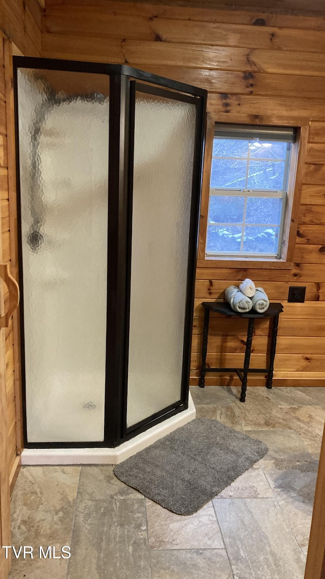 bathroom featuring wooden walls and walk in shower