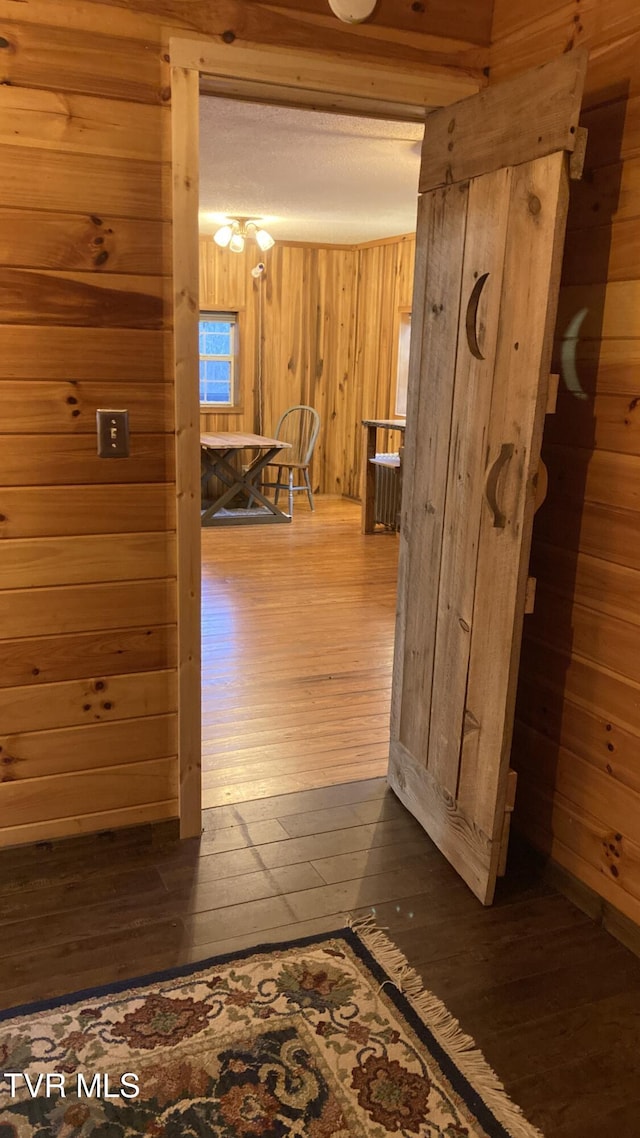 corridor featuring wood walls and dark wood-type flooring