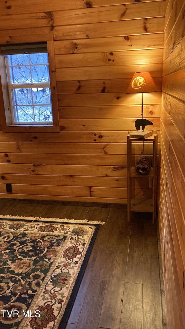 interior space with wooden walls and dark wood-type flooring