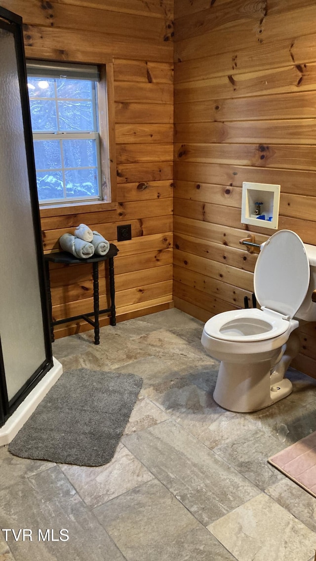 bathroom featuring wood walls and toilet