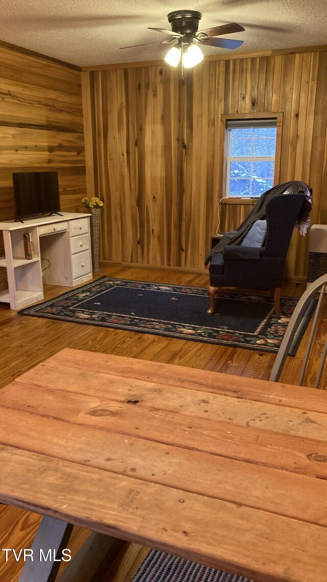 sitting room featuring ceiling fan, a textured ceiling, and hardwood / wood-style flooring