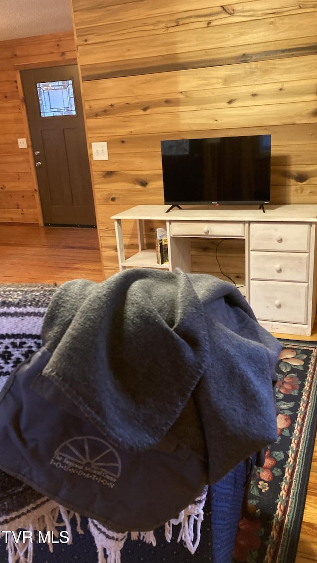 living room featuring hardwood / wood-style flooring and wooden walls