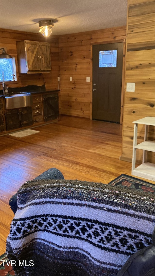 foyer entrance with wood-type flooring and a textured ceiling