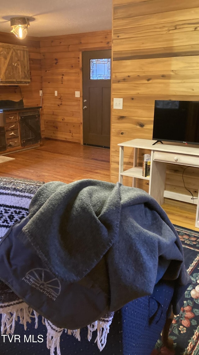 living room featuring hardwood / wood-style flooring and wooden walls