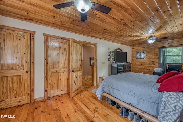 bedroom featuring light hardwood / wood-style flooring, wood walls, ceiling fan, and wooden ceiling