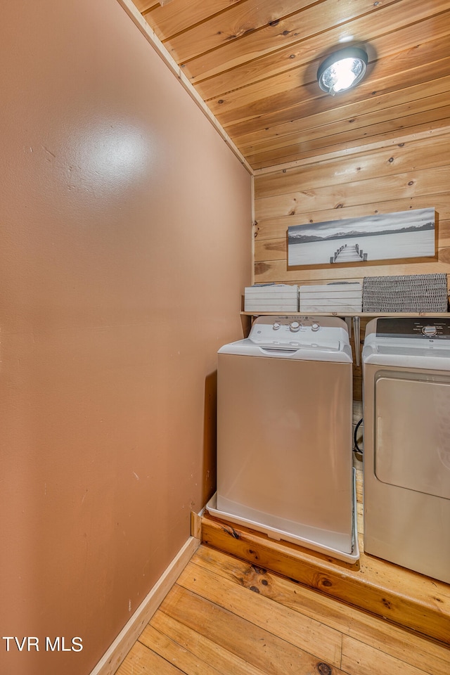 laundry room featuring light wood-type flooring, independent washer and dryer, and wooden ceiling