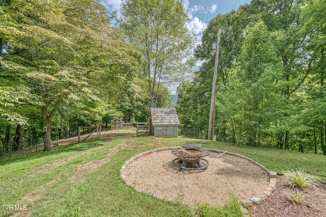 view of yard with a storage shed and a fire pit