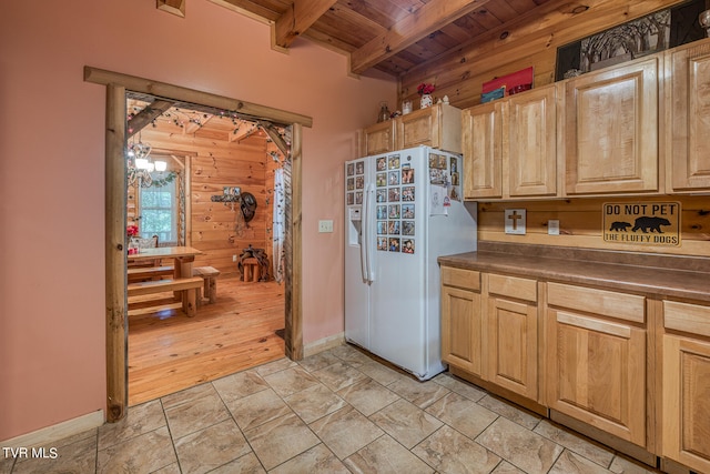 kitchen with white refrigerator with ice dispenser, wooden walls, wood ceiling, and beamed ceiling