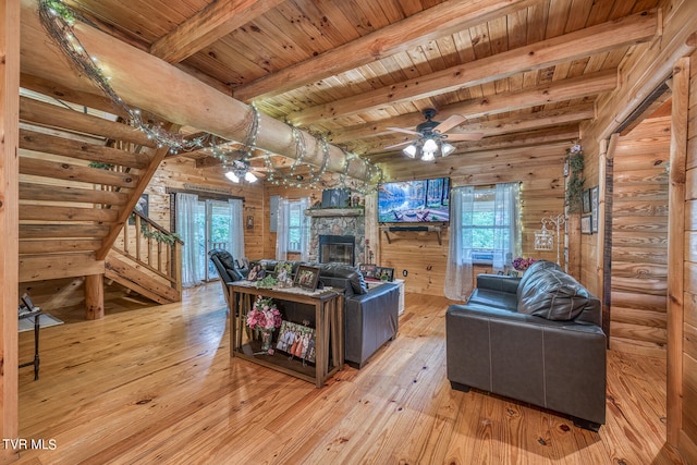 living room with light hardwood / wood-style flooring, wood ceiling, beam ceiling, and a healthy amount of sunlight