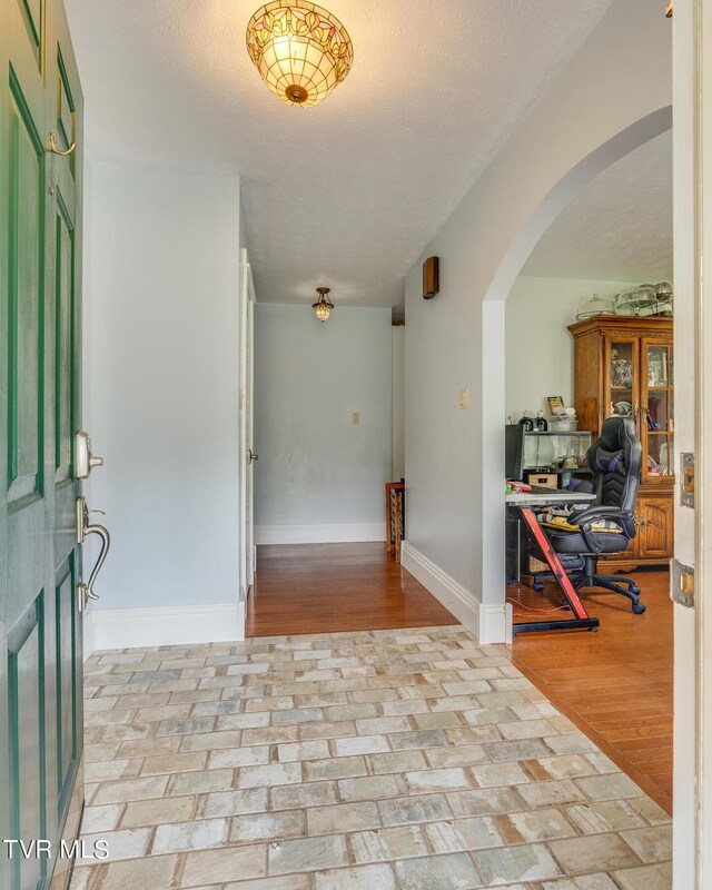 entrance foyer with a textured ceiling and light hardwood / wood-style flooring