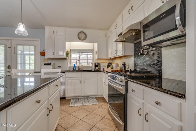 kitchen featuring sink, appliances with stainless steel finishes, tasteful backsplash, light tile patterned floors, and white cabinets