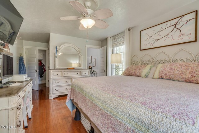 bedroom featuring hardwood / wood-style flooring, a textured ceiling, and ceiling fan