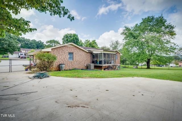 back of property featuring a sunroom and a yard