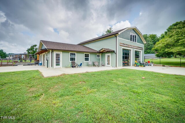 back of property featuring a lawn, french doors, and a patio