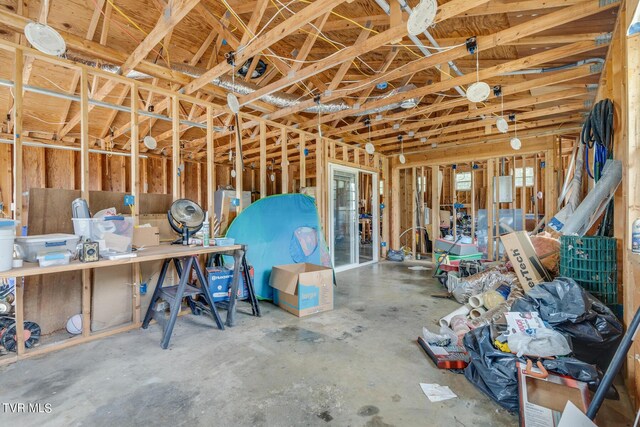 misc room featuring water heater and concrete flooring